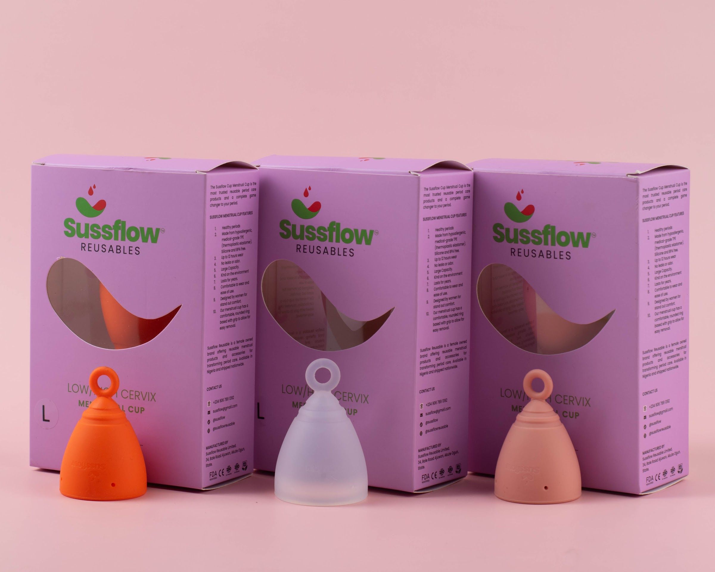 Sussflow menstrual cups in orange, clear and pink with their boxes