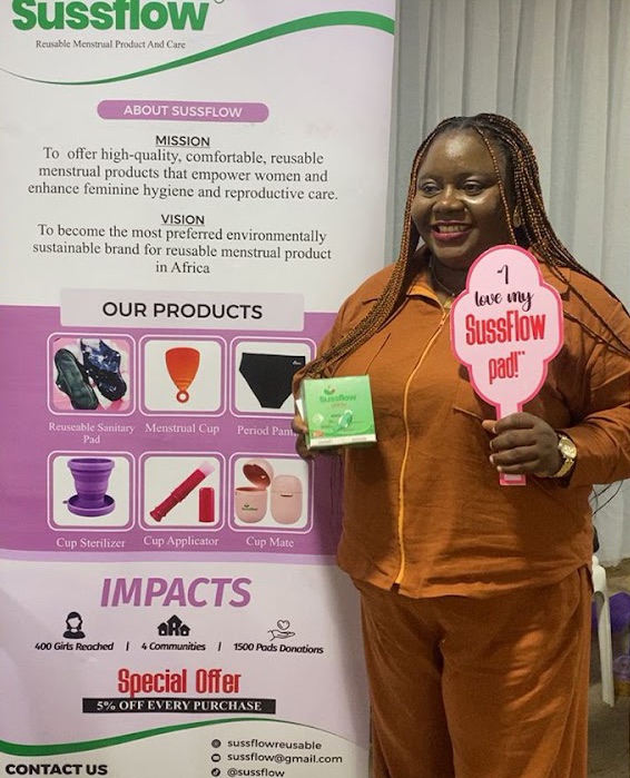 A woman at the Sussflow stand holding an “I love my Sussflow pad” sign